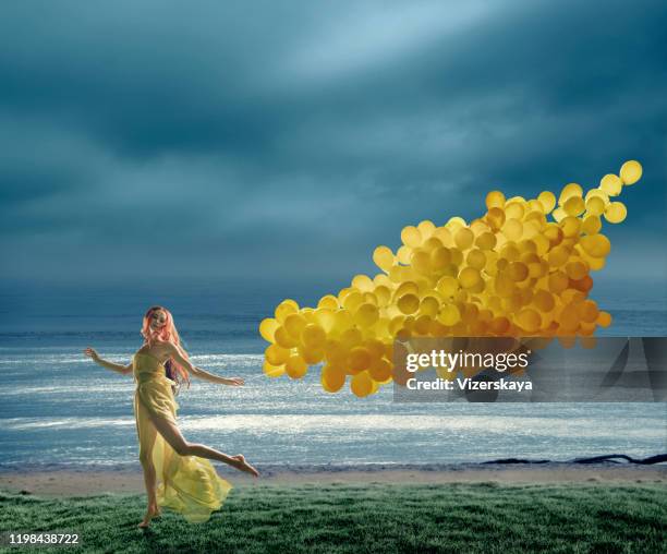 running jonge vrouwen met grote tak van gele ballonnen - dream big stockfoto's en -beelden