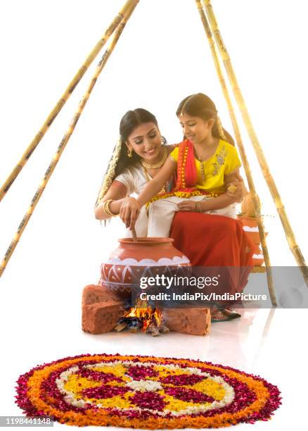 mother and daughter cooking food on pongal - pongal stockfoto's en -beelden