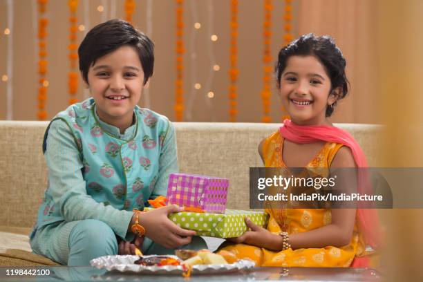 young brother and sister celebrating rakhi - bhai dooj festival celebration foto e immagini stock