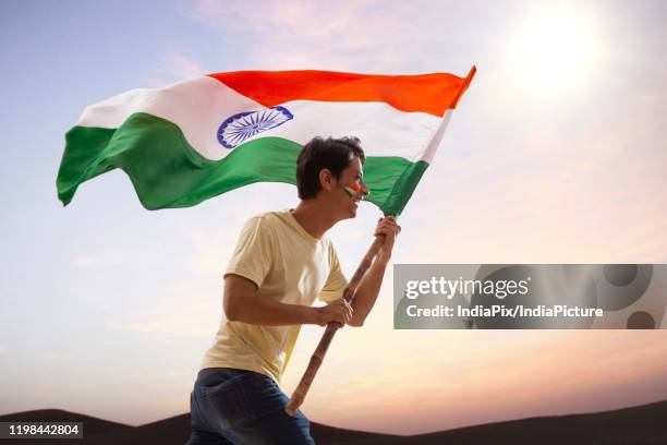 young man running with indian flag in excitement, independence day - republic day stock-fotos und bilder