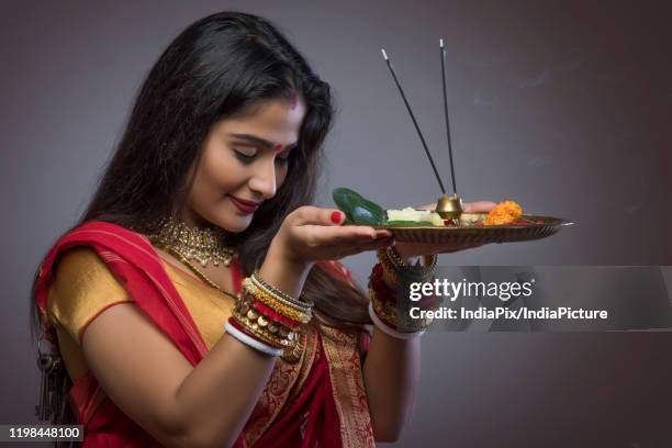 happy bengali woman praying with a pooja thali at durga puja - hinduism photos stock pictures, royalty-free photos & images