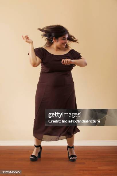 fat woman in a long brown dress dancing on high heels - fat woman dancing stockfoto's en -beelden