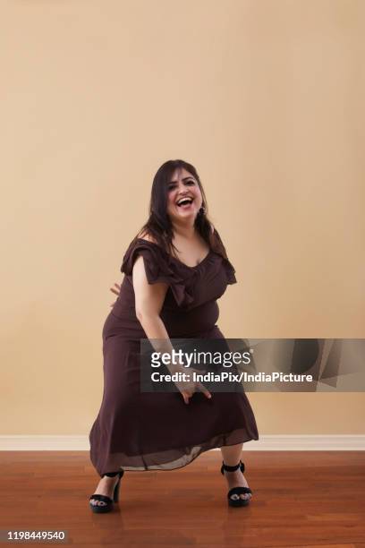 fat woman in a long brown dress dancing on high heels - fat women in high heels stock-fotos und bilder