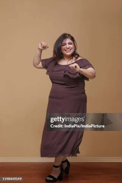 fat woman in a long brown dress dancing on high heels - fat women in high heels 個照片及圖片檔