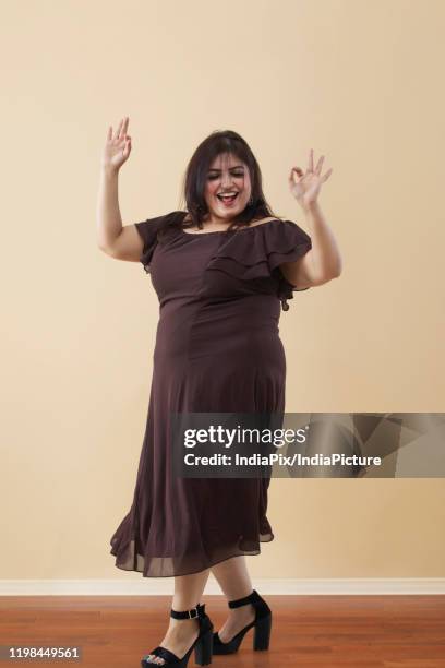 fat woman in a long brown dress dancing on high heels - fat women in high heels stock-fotos und bilder