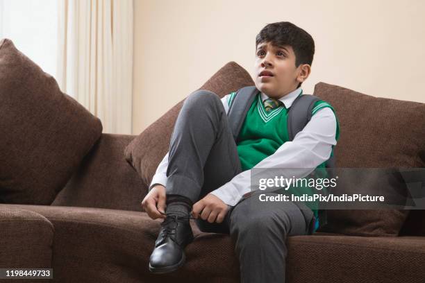 school boy tying shoes at home - school tie stock-fotos und bilder