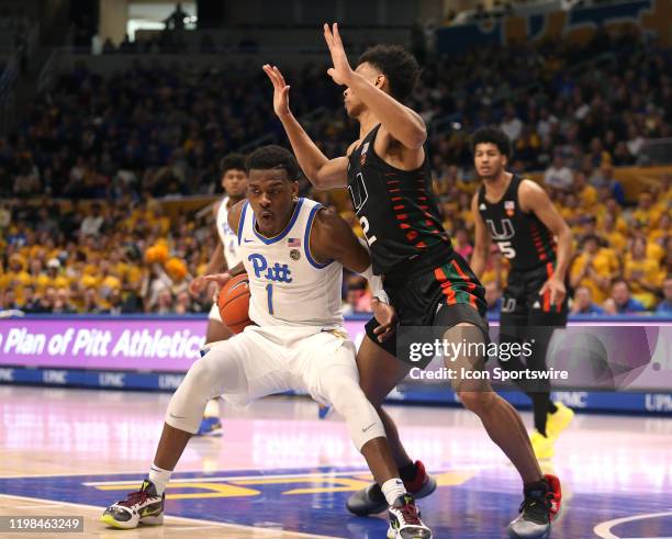 Xavier Johnson of the Pittsburgh Panthers gets halted by Isaiah Wong of the Miami Hurricanes while driving to the basket during the first half on...