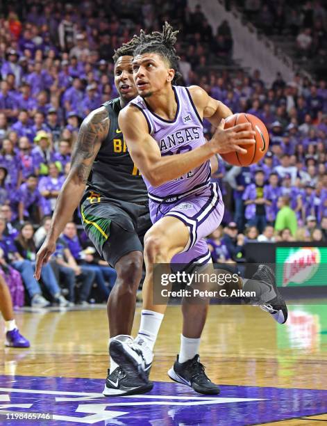 Mike McGuirl of the Kansas State Wildcats drives to the basket against Mark Vital of the Baylor Bears during the second half at Bramlage Coliseum on...