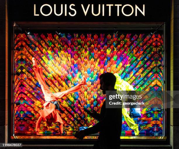 vorbei an einem louis vuitton-schaufenster - high end store fronts stock-fotos und bilder