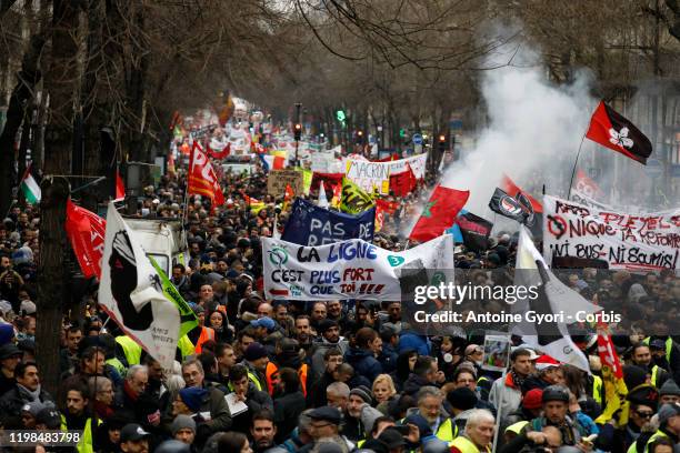 Protesters march along Magenta Boulevard during a day of protest and ongoing transport worker strikes over French pension reform plans on January 9,...