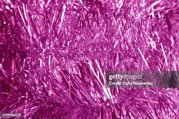 neon tinsel background with selective focus. phantom neon tinsel. christmas decoration, new year abstract background with shiny glittering tinsels. - tinsel - fotografias e filmes do acervo