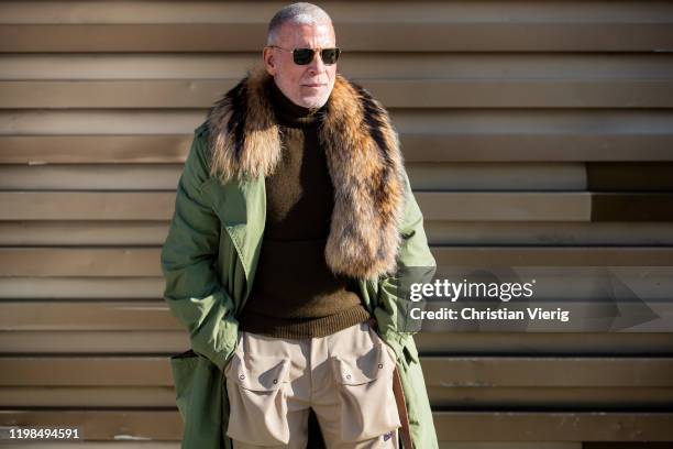 Nick Wooster seen wearing green parka, beige pants, brown turtleneck during Pitti Uomo 97 at Fortezza Da Basso on January 09, 2020 in Florence, Italy.