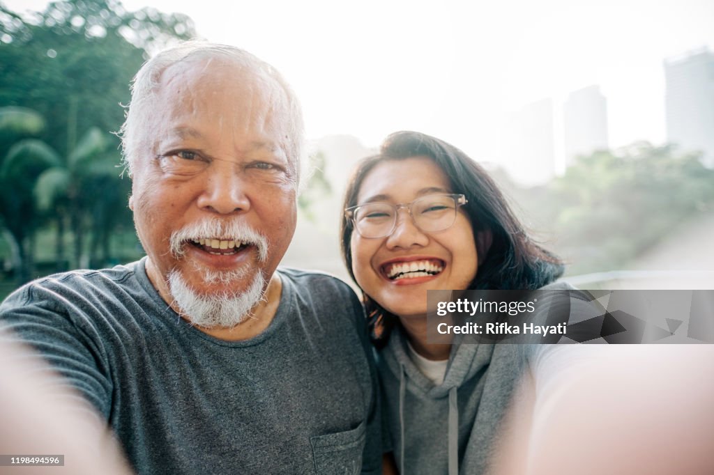 Encantador padre mayor e hija tomando selfie juntos