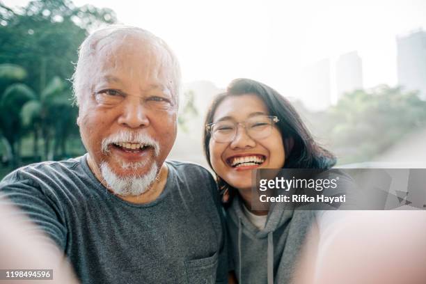 mooie senior vader en dochter nemen selfie samen - old asian man stockfoto's en -beelden