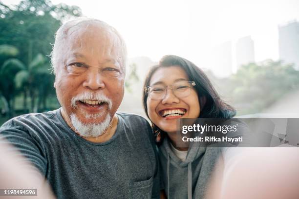 lovely senior father and daughter taking selfie together - adult selfie stock pictures, royalty-free photos & images