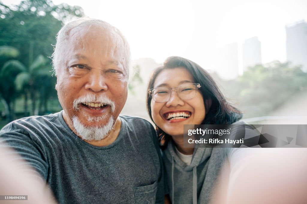 Adorável pai sênior e filha tomando selfie juntos