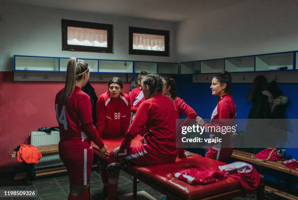 damenfußball-team im locker room - umkleideraum stock-fotos und bilder