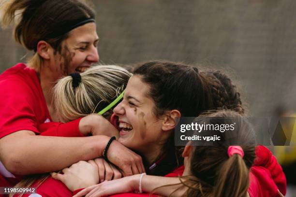gelukkige vrouwelijke voetballers vieren doel - voetbal teamsport stockfoto's en -beelden