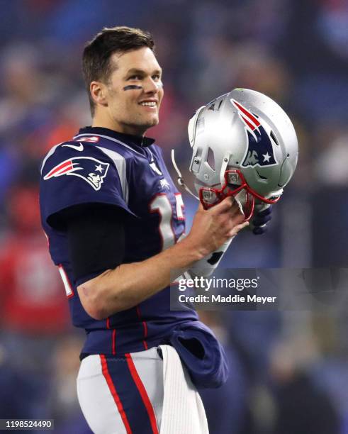 Tom Brady of the New England Patriots looks on holding his helmet before the AFC Wild Card Playoff game against the Tennessee Titans at Gillette...