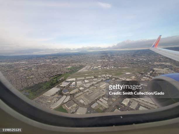 Wide angle view out window of Southwest Airlines aircraft, with wingtip visible, flying over Oakland, California, January 8, 2020.