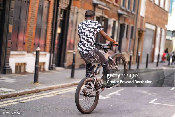 Guest wears mirrored ski goggles, a black and white Superdry camouflage t-shirt, black and light grey camouflge pants, black sneakers, and rides a...