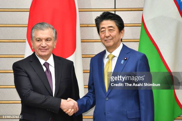 Uzbekistan President Shavkat Mirziyoyev and Japanese Prime Minister Shinzo Abe shake hands prior to their meeting at the prime minister's official...