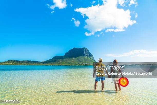 man and woman holding hands in the tropical lagoon, indian ocean, mauritius - isole mauritius stock pictures, royalty-free photos & images