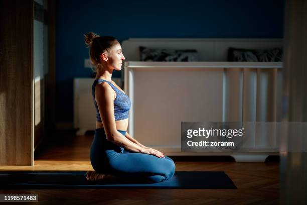 meditating at home - half lotus position stock pictures, royalty-free photos & images