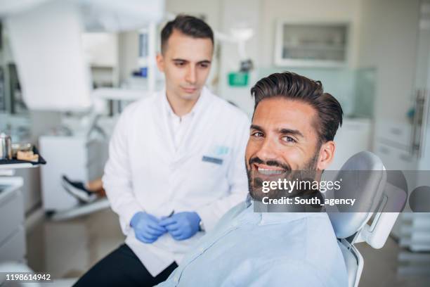 handsome gentleman at the dentist - cadeira de dentista imagens e fotografias de stock