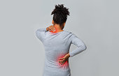 Back view of afro woman rubbing her neck and loins