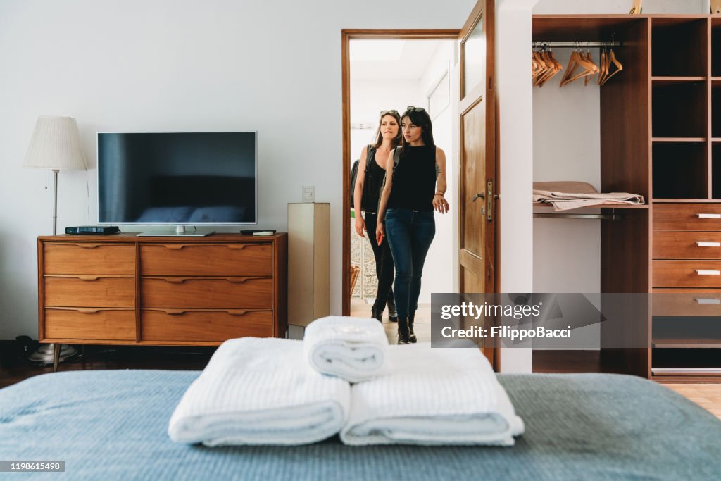 Pares adultos novos que chegam em b&b com trouxas para férias