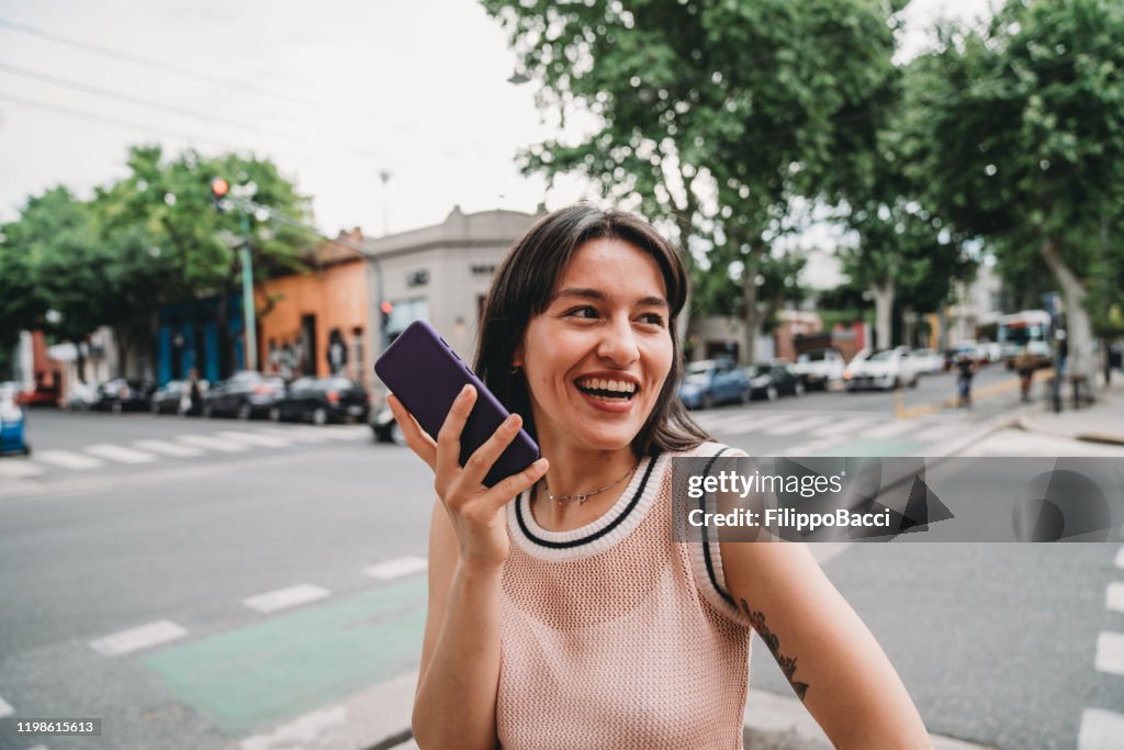 Jong volwassen vrouw het verzenden van een gesproken bericht met haar Smartphone