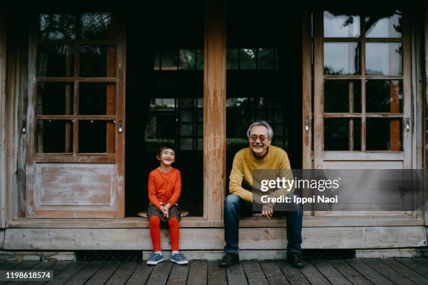 grandfather and granddaughter laughing at camera - front on portrait older full body foto e immagini stock