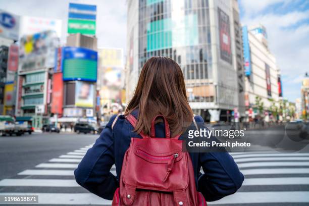 traveler crossing street at shibuya crossing with shopping mall in backgroud at tokyo, japan. famous attraction and iconic skyline view of japan. - shibuya crossing stock pictures, royalty-free photos & images