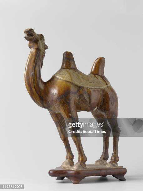 Funerary figure in the shape of a camel, Graffiti figure of earthenware, covered with a brown and cream-colored glaze. A standing camel. The figure...