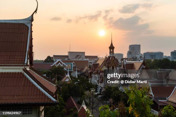 sunset over a buddhism temple in the rattanakosin old town of bangkok in thailand capital city - khao san road stock pictures, royalty-free photos & images