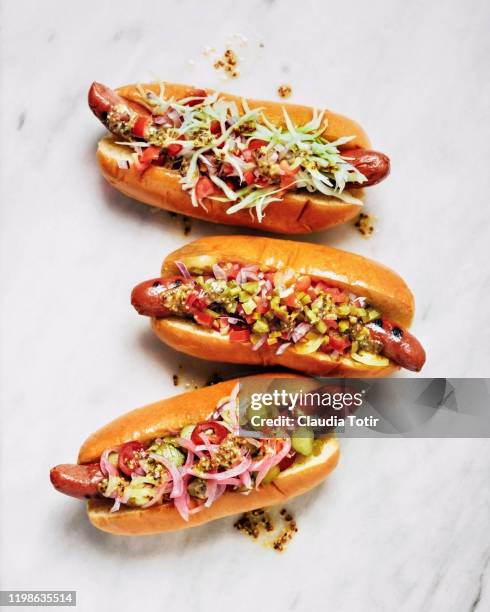 three gourmet hot dogs on white background - processed meat stock pictures, royalty-free photos & images