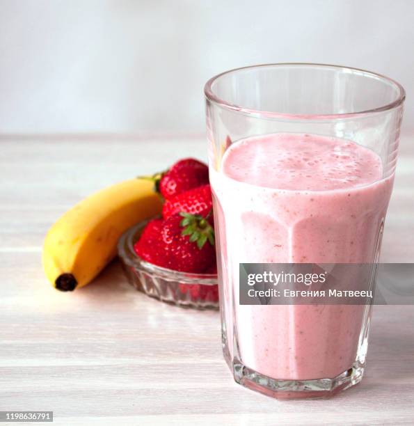 strawberry milskhake glass, bowl strawberries, banana on white. healthy eating breakfast concept - soft drink stock-fotos und bilder