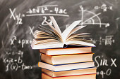 Stack of books in front of a blackboard