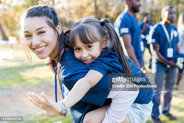 sisters volunteering together - toothy smile family outdoors stock pictures, royalty-free photos & images