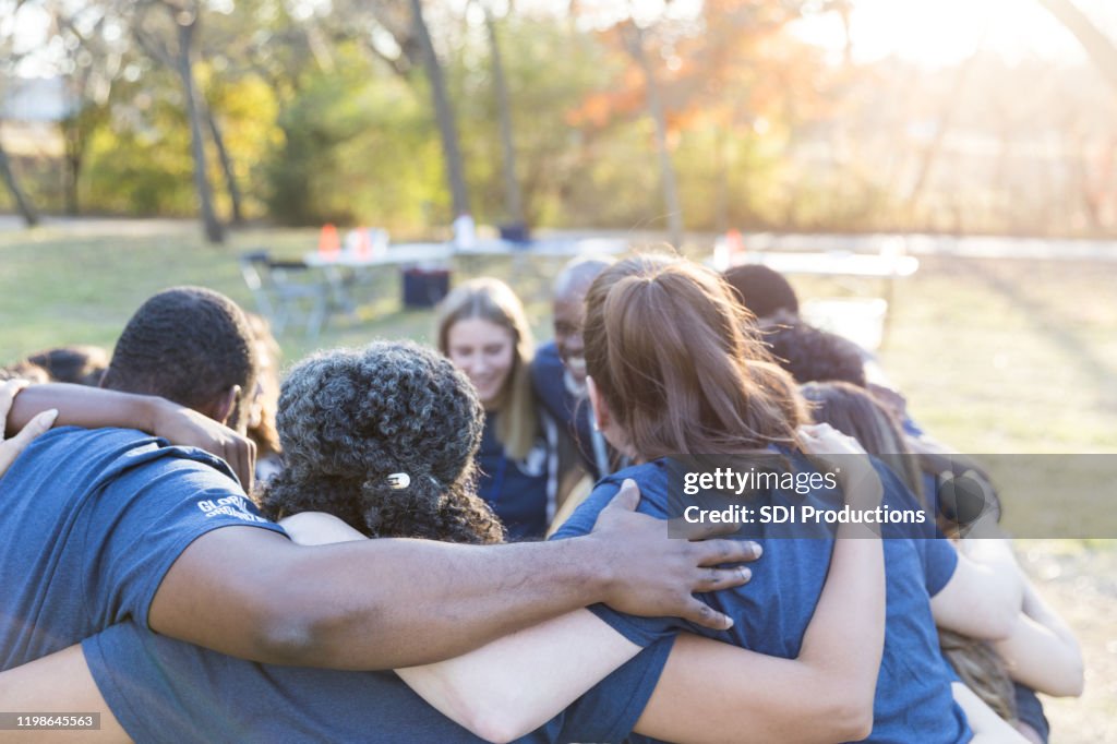 Volunteers huddle together, showing unity