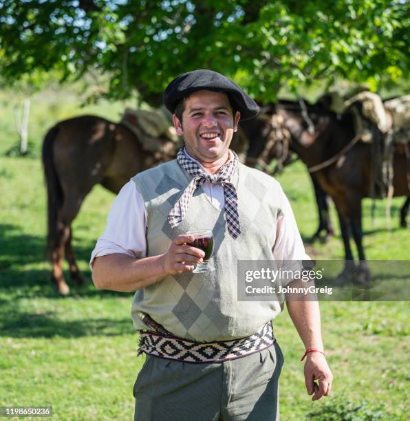 lächelnder gaucho in traditioneller kleidung entspannend im freien - gauchos stock-fotos und bilder