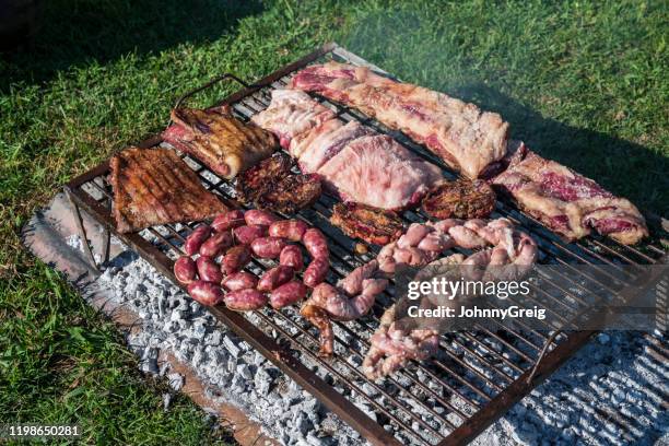 varias carnes asando para el asado tradicional argentino - argentina steak fotografías e imágenes de stock