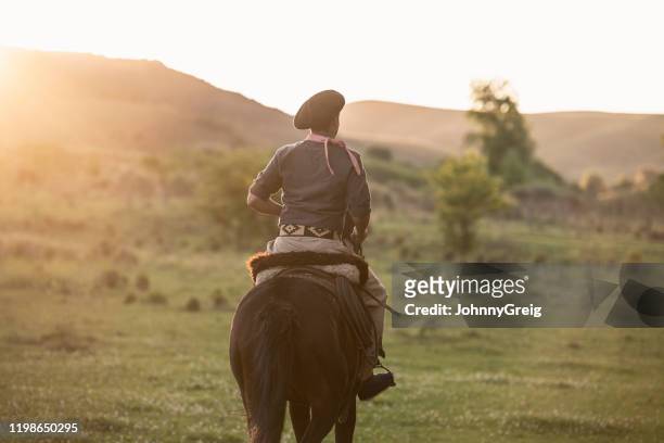 joven gaucho en ropa tradicional montando por la tarde - cordoba argentina fotografías e imágenes de stock