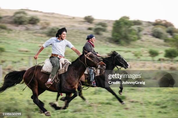 jonge argentijnse gauchos racen elkaar te paard - argentinian culture stockfoto's en -beelden