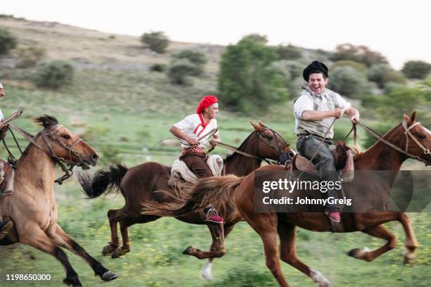 carefree argentine gauchos racing on horseback - gaucho stock pictures, royalty-free photos & images