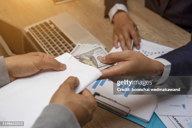 entrepreneurs are receiving money that is a bribe of their partners with both of whom are corrupt in the company room. - hiding money stock pictures, royalty-free photos & images