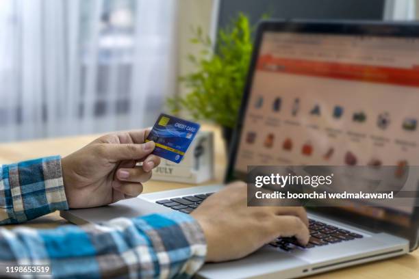 online payment,man's hands holding a credit card and using smart phone for online shopping - overdracht business mensen stockfoto's en -beelden