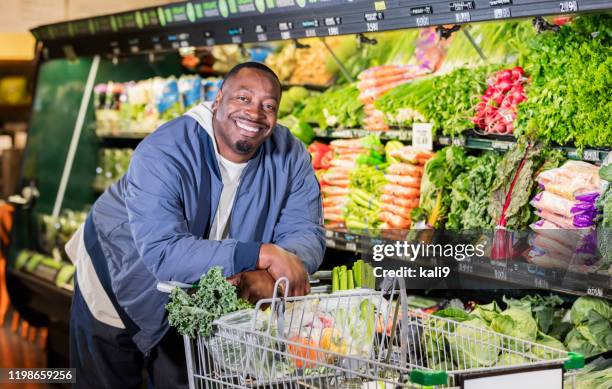 l'uomo afro-americano al supermercato produce corridoio - grasso nutrienti foto e immagini stock