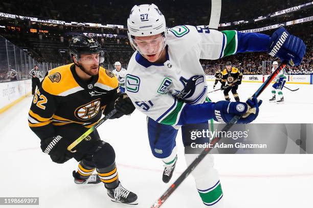 Sean Kuraly of the Boston Bruins and Tyler Myers of the Vancouver Canucks battle for the puck during a game at TD Garden on February 4, 2020 in...